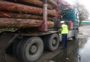 Policjant kontroluje pojazd ciężarowy z naczepą