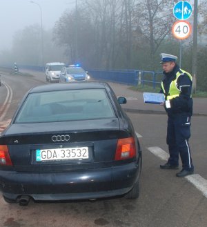 Policjant wykonuje oględziny samochodu