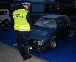 policjant podczas wykonywania oględzin pojazdu