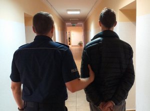 policjant prowadzi zatrzymanego