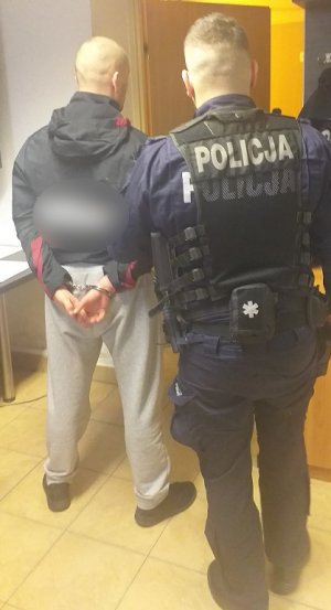 policjant prowadzi zatrzymanego