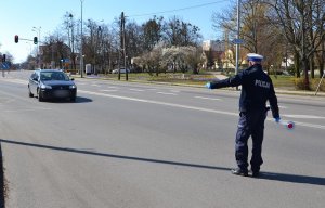 policjant podczas zatrzymywania pojazdu do kontroli