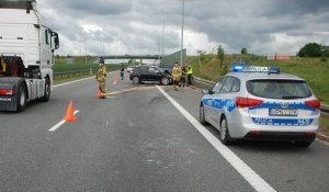 radiowóz policyjny i policjant podczas czynności na miejscu zdarzenia