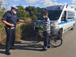 policjant w trakcie wręczania odblasków rowerzyście