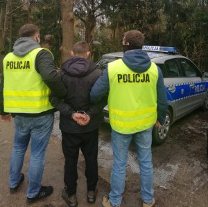 policjanci podczas doprowadzania zatrzymanego