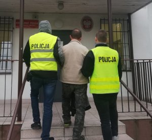 policjanci podczas doprowadzania zatrzymanego