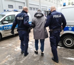 policjanci podczas doprowadzania zatrzymanego