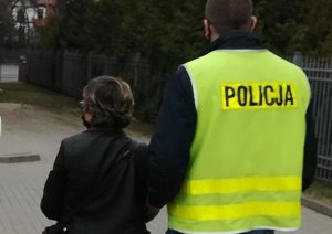 policjant podczas doprowadzania zatrzymanej