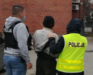 policjanci podczas doprowadzania zatrzymanego