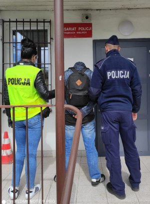 policjanci podczas doprowadzania zatrzymanego