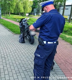 policjant podczas wykonywania oględzin motocykla