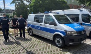 policjanci podczas doprowadzania zatrzymanego