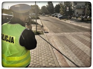 policjant podczas pomiaru prędkości w rejonie przejścia dla pieszych