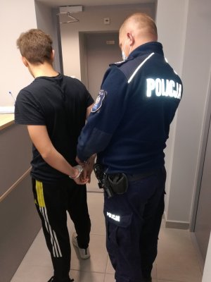 policjant podczas zakładania kajdanek zatrzymanemu