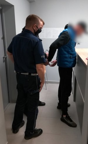 policjanci podczas doprowadzania zatrzymanego