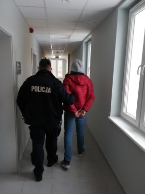 policjant podczas doprowadzania zatrzymanego