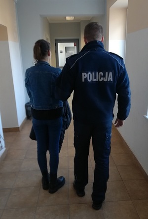 policjant podczas doprowadzania zatrzymanej