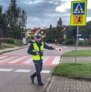 policjant podczas zatrzymywania pojazdu do kontroli