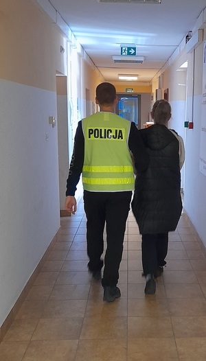 policjant podczas doprowadzania zatrzymanej