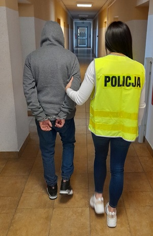 policjantka podczas doprowadzania zatrzymanego