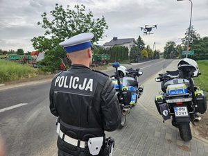 policjant podczas służby z wykorzystaniem drona i motocykla