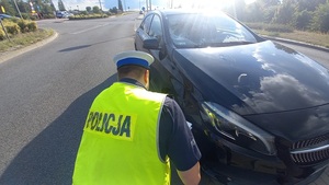 policjant podczas wykonywania oględzin pojazdu