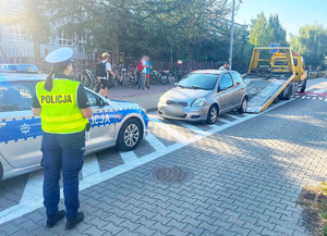 policjantka i radiowóz policyjny podczas czynności