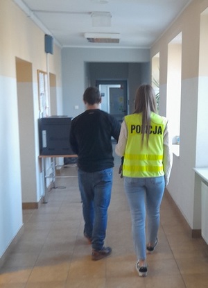 policjantka podczas doprowadzania zatrzymanego