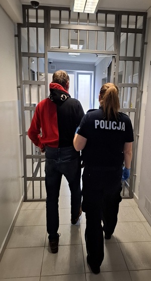 policjantka podczas doprowadzania zatrzymanego