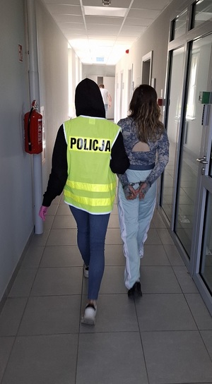 policjantka podczas doprowadzenia zatrzymanego