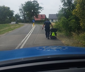 policjant podczas pomagania przy awarii wózka