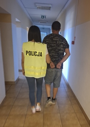 policjantka podczas doprowadzania zatrzymanego