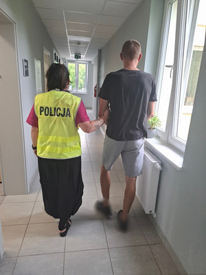 policjantka podczas doprowadzania zatrzymanego