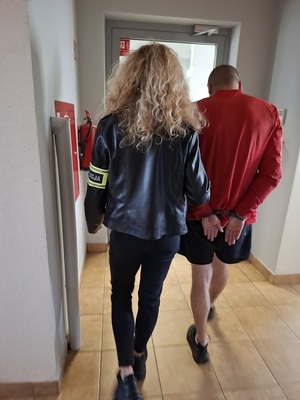 policjantka podczas doprowadzania zatrzymanego