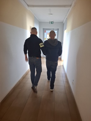 policjant podczas doprowadzenia