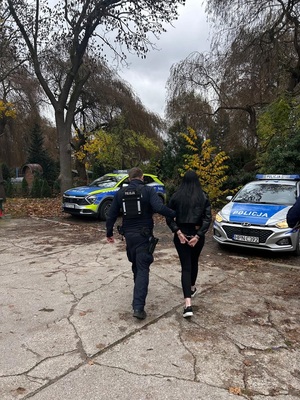 policjant podczas doprowadzania zatrzymanego