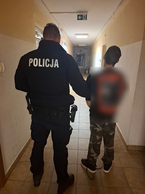 policjant podczas doprowadzania zatrzymanego