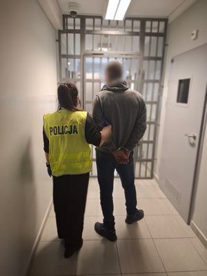 policjantka podczas doprowadzania zatrzymanego