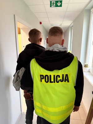 policjant podczas doprowadzania zatrzymanego