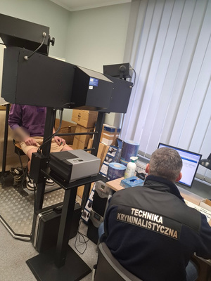 technik policyjny podczas czynności z zatrzymanym