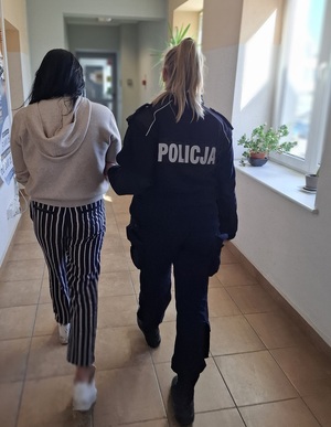 policjantka podczas doprowadzania zatrzymanego