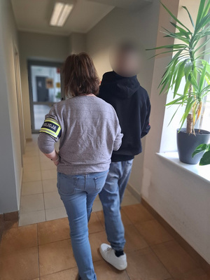 policjantka podczas doprowadzenia zatrzymanego