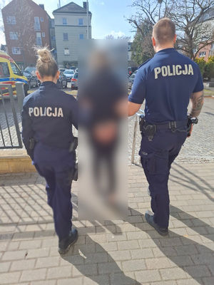 policjanci podczas doprowadzenia osoby zatrzymanej