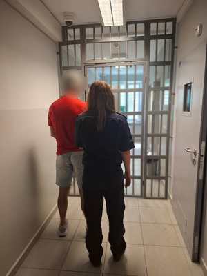 policjantka podczas doprowadzania zatrzymanego