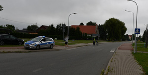 policjant i policyjny radiowóz na miejscu zdarzenia