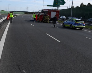 policjanci i radiowóz policyjny na miejscu wypadku motocyklistki